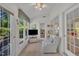 Bright sunroom showcasing tile floors, a ceiling fan, and a comfortable armchair at 105 Breakers Pl, Cary, NC 27511