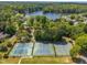 Aerial view of well maintained community tennis courts with lake in the background surrounded by mature landscaping and trees at 105 Breakers Pl, Cary, NC 27511