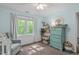 Bedroom with a large window, soft blue walls, rocker and dresser with mirror at 107 Candy Apple Ct, Cary, NC 27513