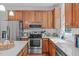 Well-equipped kitchen featuring stainless steel appliances, white countertops, and ample wooden cabinetry at 107 Candy Apple Ct, Cary, NC 27513