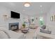 Inviting living room showcasing a cozy fireplace, plush seating, and natural light from surrounding windows at 107 Candy Apple Ct, Cary, NC 27513