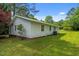 Exterior view highlighting the white siding, windows, with lush green lawn and mature trees at 108 Deepwood Cir, Garner, NC 27529
