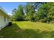 Spacious backyard with lush lawn, mature trees, and partial view of the home's exterior at 108 Deepwood Cir, Garner, NC 27529