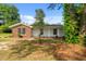 Single-story home with brick and white siding surrounded by lush greenery and mature trees at 108 Deepwood Cir, Garner, NC 27529