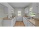 Bright kitchen with white cabinetry, tile floors, granite countertops, and stainless-steel sink at 108 Deepwood Cir, Garner, NC 27529