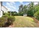 Large, well-maintained backyard with green grass, mature trees, privacy shrubs, and a wooden shed at 1209 Shasta Daisy Dr, Wake Forest, NC 27587