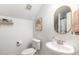 Bright half bathroom featuring a pedestal sink, framed mirror, and modern decor at 1209 Shasta Daisy Dr, Wake Forest, NC 27587