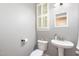Cozy bathroom with a pedestal sink, white toilet, and window with wooden shutters at 1209 Shasta Daisy Dr, Wake Forest, NC 27587