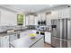 Well-lit kitchen boasts white cabinetry, stainless steel appliances, and a large island at 1209 Shasta Daisy Dr, Wake Forest, NC 27587