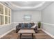 Comfortable sitting room with modern furniture, a decorative tray ceiling, and bright natural light at 1209 Shasta Daisy Dr, Wake Forest, NC 27587