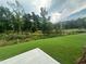 Backyard with lush lawn and view of greenbelt with mature trees at 1252 Randwick Vly Ct, Zebulon, NC 27597