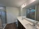 Bright bathroom featuring double sink vanity, quartz countertop and sleek glass-enclosed shower at 1252 Randwick Vly Ct, Zebulon, NC 27597