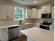 Modern kitchen with white cabinets, stainless steel appliances, quartz countertops, and an island at 1252 Randwick Vly Ct, Zebulon, NC 27597