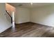 Open-concept living area with hardwood floors and a staircase leading to the upper level of the home at 1252 Randwick Vly Ct, Zebulon, NC 27597