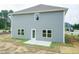 Back exterior view showing vinyl siding, well placed windows, and a small patio surrounded by a green space at 127 High Hampton Way, Fuquay Varina, NC 27526