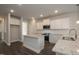 Modern kitchen boasts white cabinetry, granite counters, stainless steel appliances, and functional center island at 127 High Hampton Way, Fuquay Varina, NC 27526
