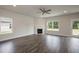 Spacious living room featuring a fireplace, large windows, and contemporary ceiling fan at 127 High Hampton Way, Fuquay Varina, NC 27526