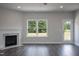 Cozy living room boasts a marble fireplace, backyard views from the large windows, and modern lighting at 127 High Hampton Way, Fuquay Varina, NC 27526