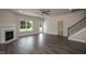 Open-concept living room with fireplace, staircase, and ample natural light at 127 High Hampton Way, Fuquay Varina, NC 27526