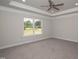 Expansive primary bedroom has a tray ceiling, carpet, and large windows at 127 High Hampton Way, Fuquay Varina, NC 27526