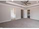 Primary bedroom features a ceiling fan, carpet, and an open doorway to an ensuite bathroom and walk-in closet at 127 High Hampton Way, Fuquay Varina, NC 27526