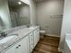 Modern bathroom with double sinks, granite countertops, and wood flooring at 127 Oakfield Trace Dr, Four Oaks, NC 27524