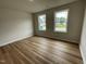 Bright bedroom with new wood flooring, two large windows, and neutral walls at 127 Oakfield Trace Dr, Four Oaks, NC 27524