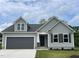 Charming home with gray siding, black shutters, gray garage door, and well-manicured lawn at 127 Oakfield Trace Dr, Four Oaks, NC 27524