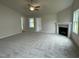 Spacious living room featuring a fireplace, carpet floors, and bright windows at 127 Oakfield Trace Dr, Four Oaks, NC 27524