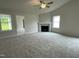 Cozy living room with a fireplace, neutral carpet, and plenty of natural light at 127 Oakfield Trace Dr, Four Oaks, NC 27524