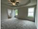 Spacious main bedroom features a tray ceiling, ceiling fan, carpeted floor, and two windows at 127 Oakfield Trace Dr, Four Oaks, NC 27524