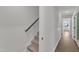 Hallway showing staircase with carpeted steps and wooden banister at 1272 Brown Velvet Ln, Apex, NC 27523