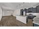 A view of an open concept kitchen that features gray cabinets and a granite countertop kitchen island at 1272 Brown Velvet Ln, Apex, NC 27523