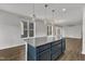 An open-concept kitchen with gray cabinets, a large island with granite countertops, and modern pendant lighting at 1272 Brown Velvet Ln, Apex, NC 27523