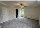 A neutral bedroom featuring gray carpet, a ceiling fan, a window, and two closets at 139 Oakfield Trace Dr, Four Oaks, NC 27524