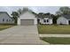 Charming single-story home featuring a gray garage door, light gray siding, and a well-manicured lawn at 139 Oakfield Trace Dr, Four Oaks, NC 27524