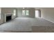 Bright, open living room with a fireplace, plush carpet, and lots of natural light from several windows at 139 Oakfield Trace Dr, Four Oaks, NC 27524