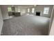 Bright, open living room leading into the kitchen and plush carpet with lots of natural light from several windows at 139 Oakfield Trace Dr, Four Oaks, NC 27524