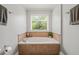 Relaxing soaking tub with tile surround and a scenic window view at 140 Crystal Pl, Benson, NC 27504