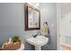 Powder room featuring blue walls, pedestal sink, and decorative mirror at 140 Crystal Pl, Benson, NC 27504