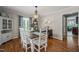 Bright dining area with farmhouse-style table, white chairs, and natural light from the window at 140 Crystal Pl, Benson, NC 27504