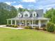 Beautifully landscaped home with a metal roof and a spacious front porch featuring a relaxing swing at 140 Crystal Pl, Benson, NC 27504