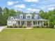 Charming home featuring a metal roof, inviting front porch with columns, and a well-maintained lawn at 140 Crystal Pl, Benson, NC 27504