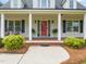 Inviting front porch with classic columns, a bright red door, and manicured landscaping at 140 Crystal Pl, Benson, NC 27504