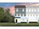 Charming townhouse featuring board and batten siding and well-manicured lawn with attractive sunset in the background at 1484 Hasse Ave, Apex, NC 27502