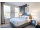 Comfortable bedroom featuring large windows, gray carpet, stylish decor, and natural light at 1486 Hasse Ave, Apex, NC 27502