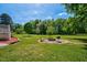 A backyard with a fire pit and chairs on a sunny day at 1576 Cheves Rd, Zebulon, NC 27597