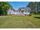 This backyard features a deck, a stone fire pit, a lawn, and a white home at 1576 Cheves Rd, Zebulon, NC 27597