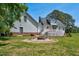 This backyard has a stone fire pit, a lawn, a white house, and a green tree at 1576 Cheves Rd, Zebulon, NC 27597