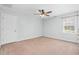 This bedroom has carpet, light-colored walls, a ceiling fan, and a window at 1576 Cheves Rd, Zebulon, NC 27597